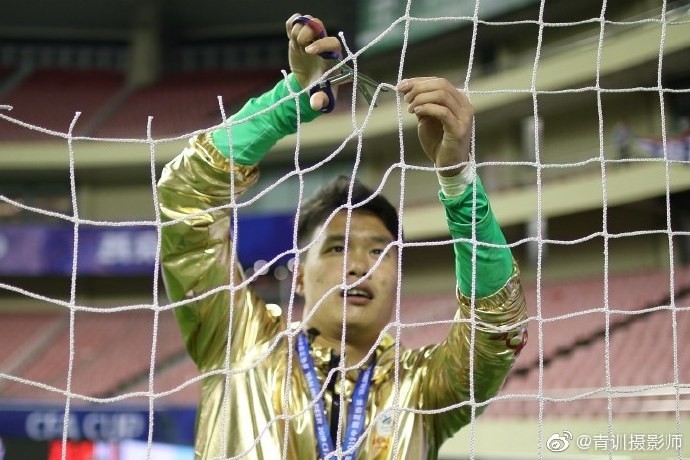 申花夺冠后,门将陈钊剪下虹口足球场的球网作为纪念